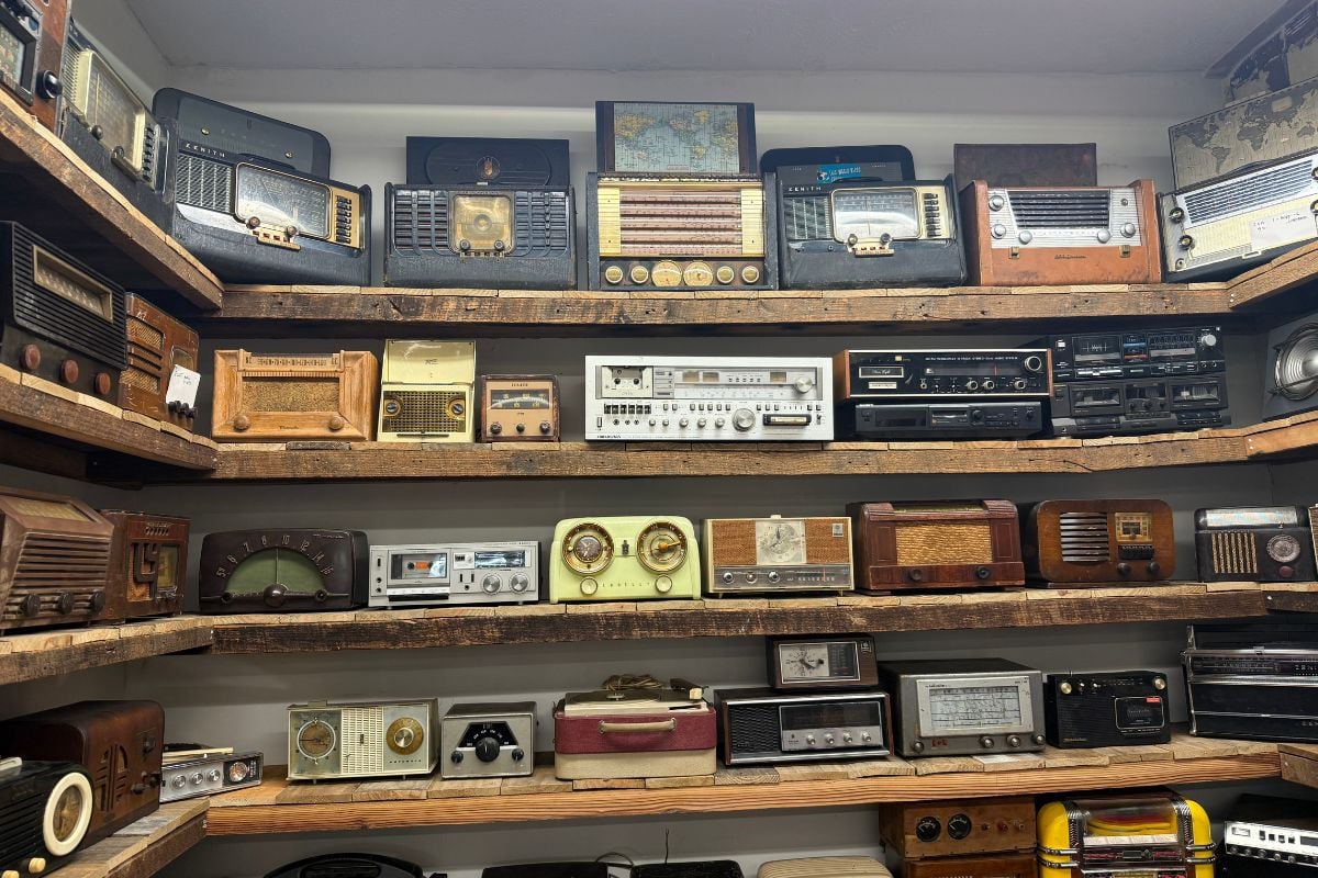 Rows of vintage radios on a shelf inside a vintage radio museum.