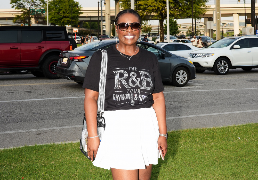 Woman wearing R&B Tour t-shirt outside Protective Stadium parking lot before Chris Brown and Usher concert in Birmingham.