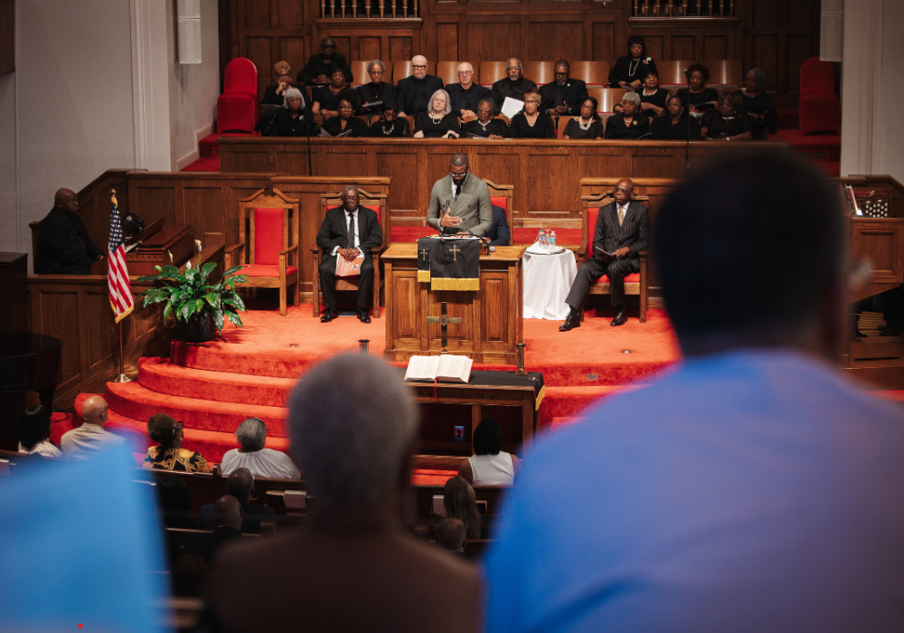 Mayor Randall Woodfin standing in pulpit delivering a greeting to attendees of the 16th Street Education & Visitors center opening.